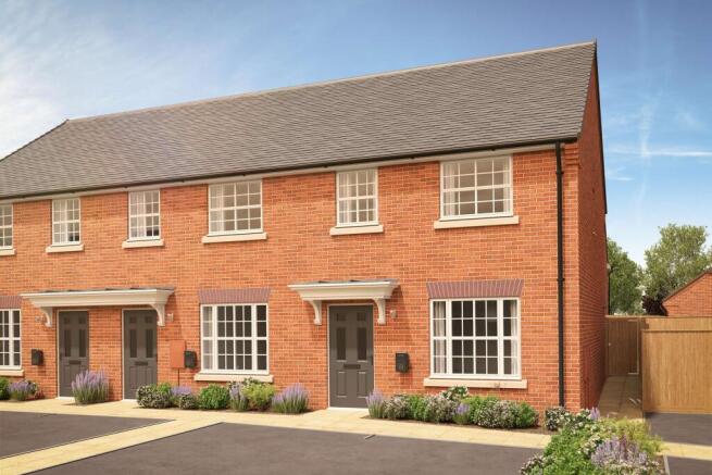 A row of modern brick townhouses with manicured gardens in the foreground stands against a bright bl