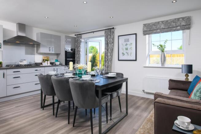 Open-plan kitchen/diner with integrated appliances and French doors leading onto garden in Ingleby s