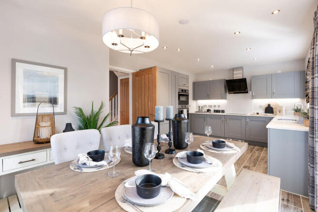 A modern and stylish kitchen with a dining area, featuring gray cabinets, wooden countertops