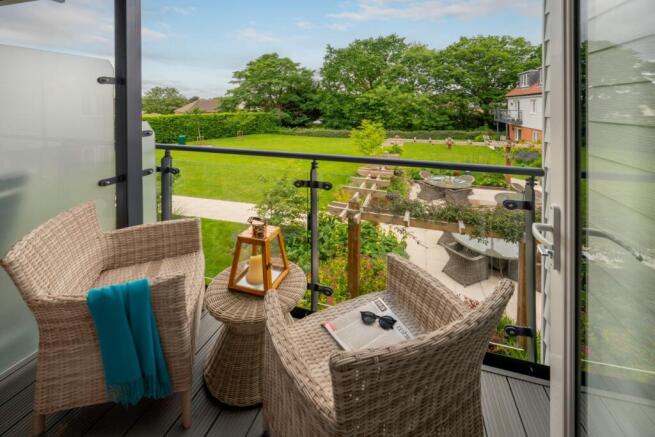 View of the communal gardens from a representative apartment featuring a balcony