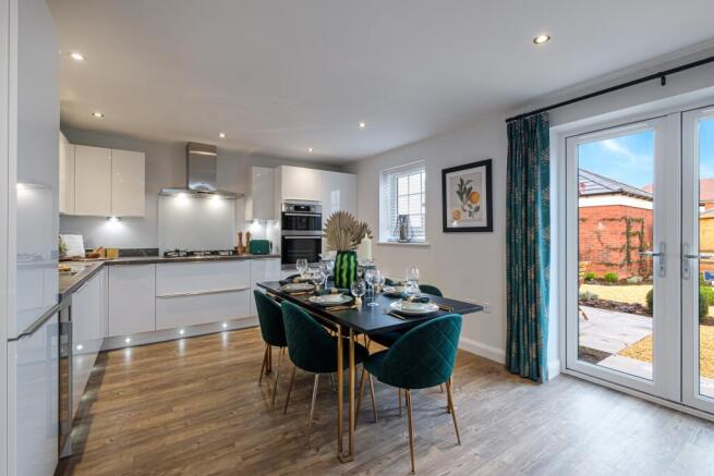Large kitchen with blue chairs and French doors to garden