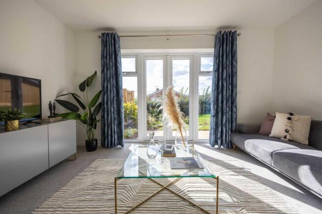 A cozy living room with a glass coffee table, a gray sofa