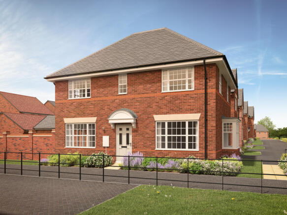 A red brick house with a white door and large windows sits behind a low fence and flowerbed