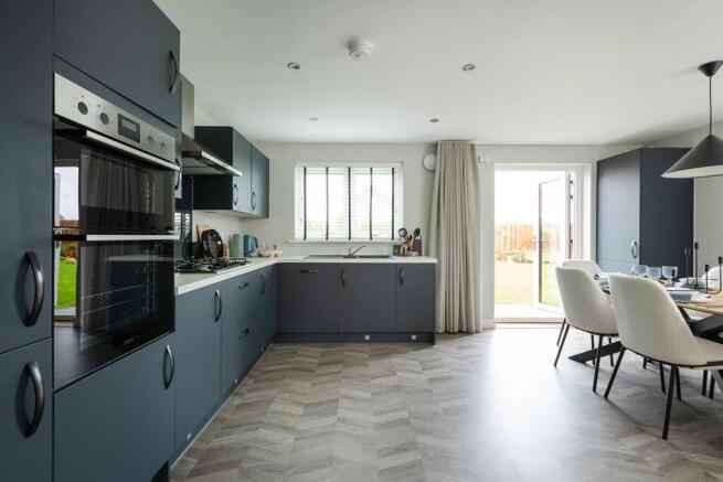 The spacious kitchen/dining area has double doors to the rear garden