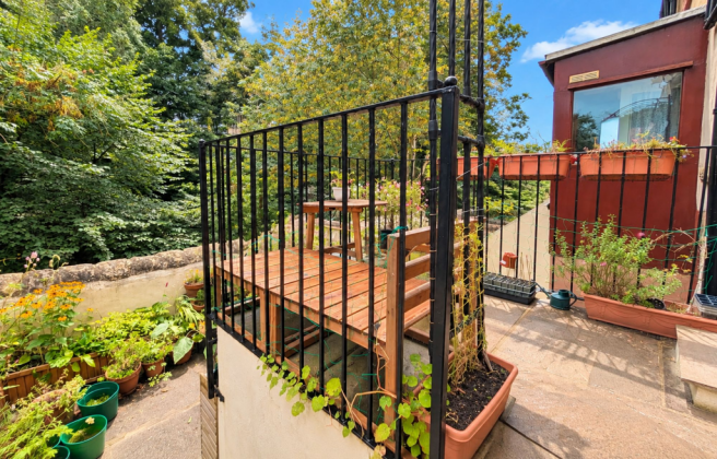 A Raised Garden Terrace With A Woodland Backdrop